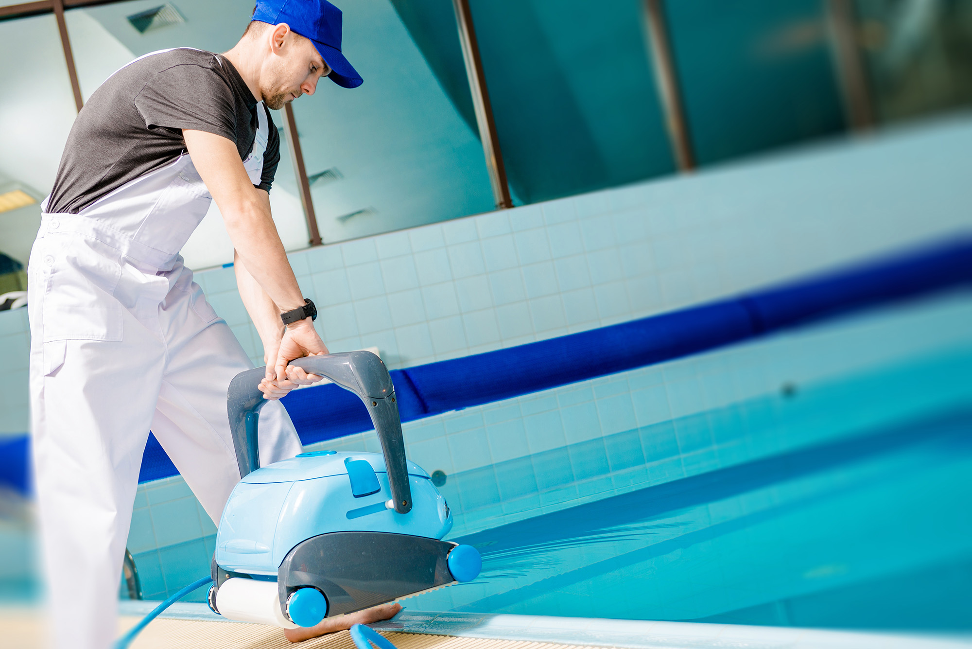 Homme nettoyant la piscine